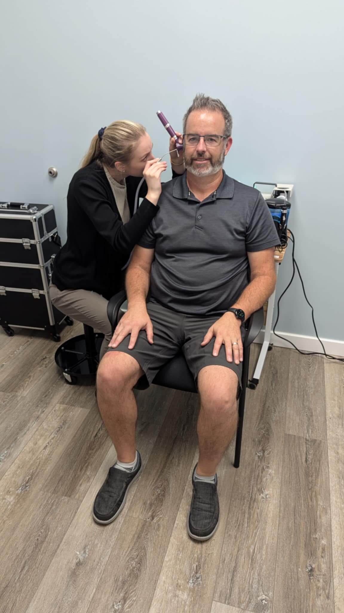 Daniela, employee of Creekside Hearing, doing wax removal on a patient with suction